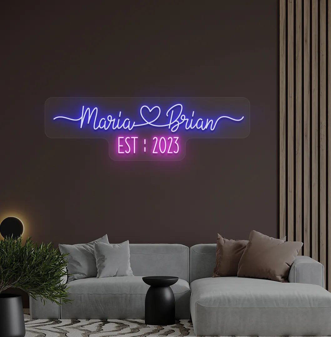 Romantic custom Couple Name EST neon sign glowing blue on aesthetic wall.