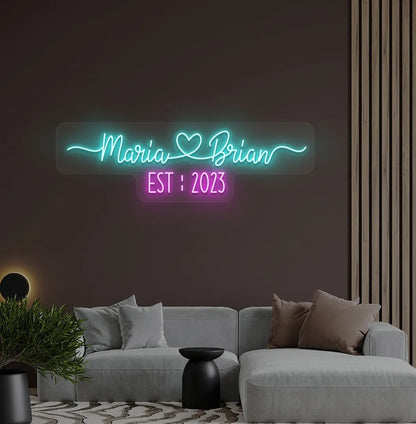 Romantic custom Couple Name EST neon sign glowing ice blue on aesthetic wall.