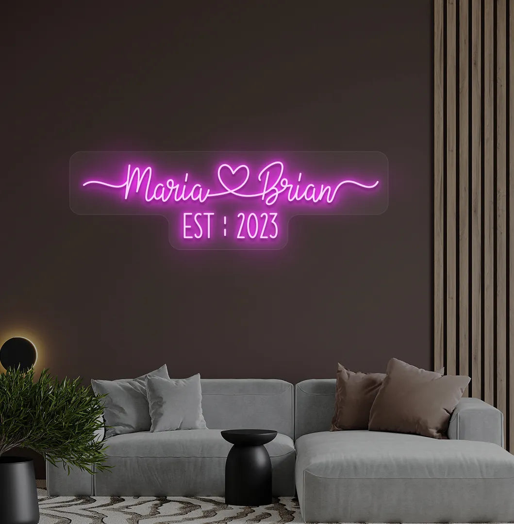 Romantic custom Couple Name EST neon sign glowing pink on aesthetic wall.