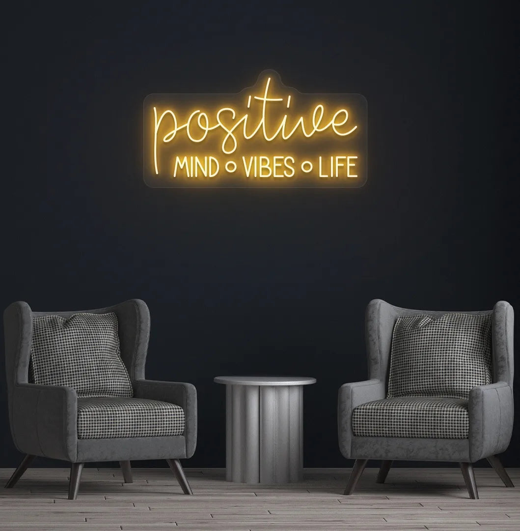 Stylish Positive Mind Vibes Life neon sign mounted on aesthetic room wall in orange color.