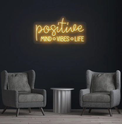 Stylish Positive Mind Vibes Life neon sign mounted on aesthetic room wall in orange color.