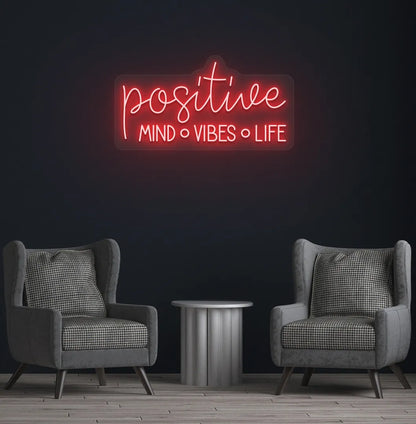Inspirational Positive Mind Vibes Life neon sign glowing red on modern wall.