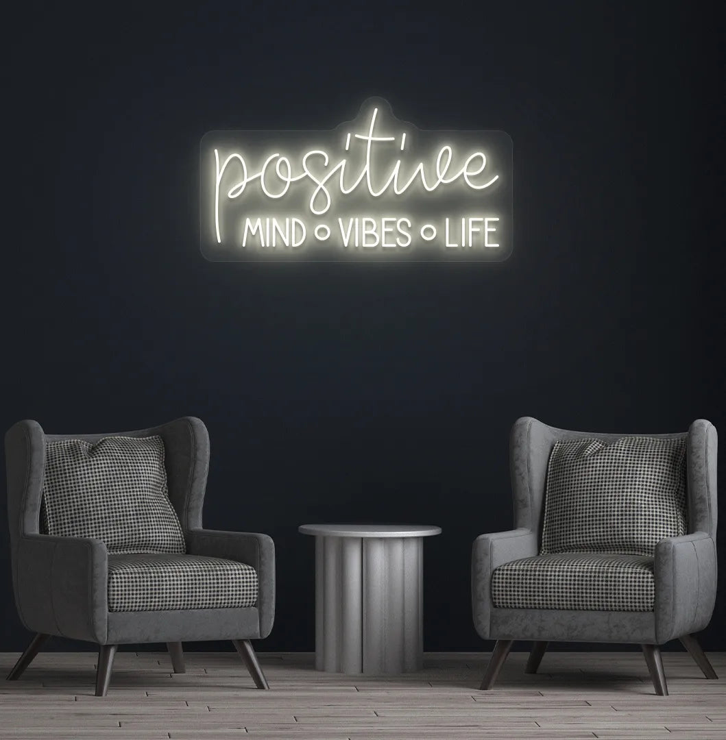 Stylish Positive Mind Vibes Life neon sign mounted on aesthetic room wall in warm white color.