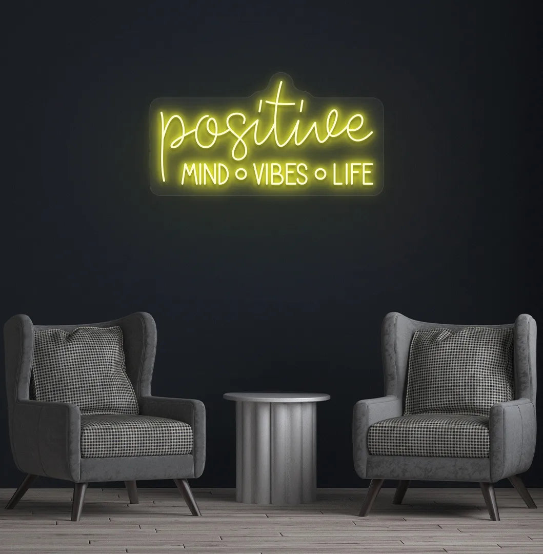 Stylish Positive Mind Vibes Life neon sign mounted on aesthetic room wall in yellow color.