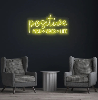 Stylish Positive Mind Vibes Life neon sign mounted on aesthetic room wall in yellow color.
