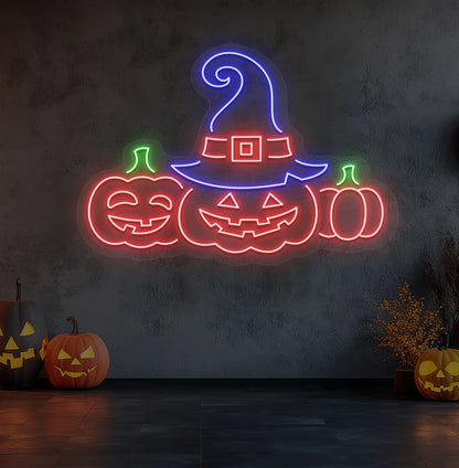 Modern wall decor with pumpkins Halloween neon sign glowing red.