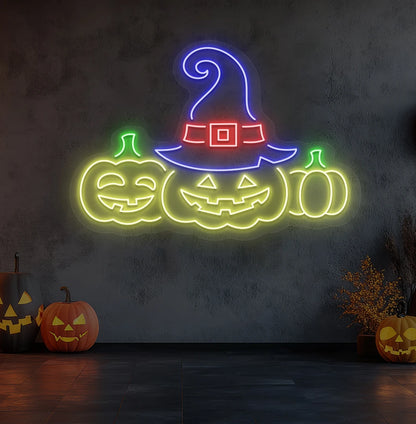 Spooky pumpkins Halloween neon sign in yellow mounted on room wall.