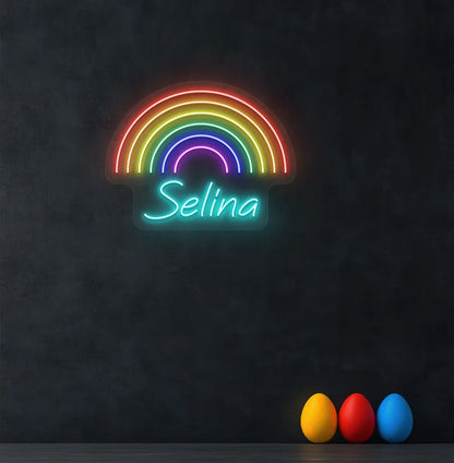 Personalized Rainbow Name neon sign in ice blue color mounted on modern wall.
