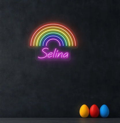 Personalized Rainbow Name neon sign in pink color mounted on modern wall.