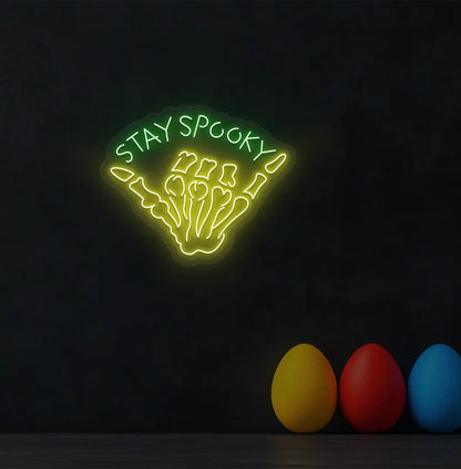 Skeleton Hand Green Neon Sign creating a spooky glow on a Halloween themed wall.