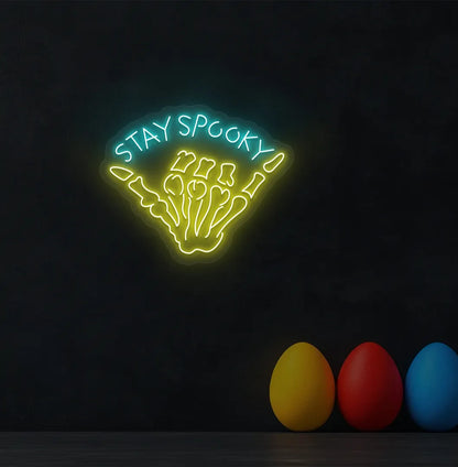 Ice Blue Skeleton Hand Neon Sign glowing on a spooky Halloween themed wall.