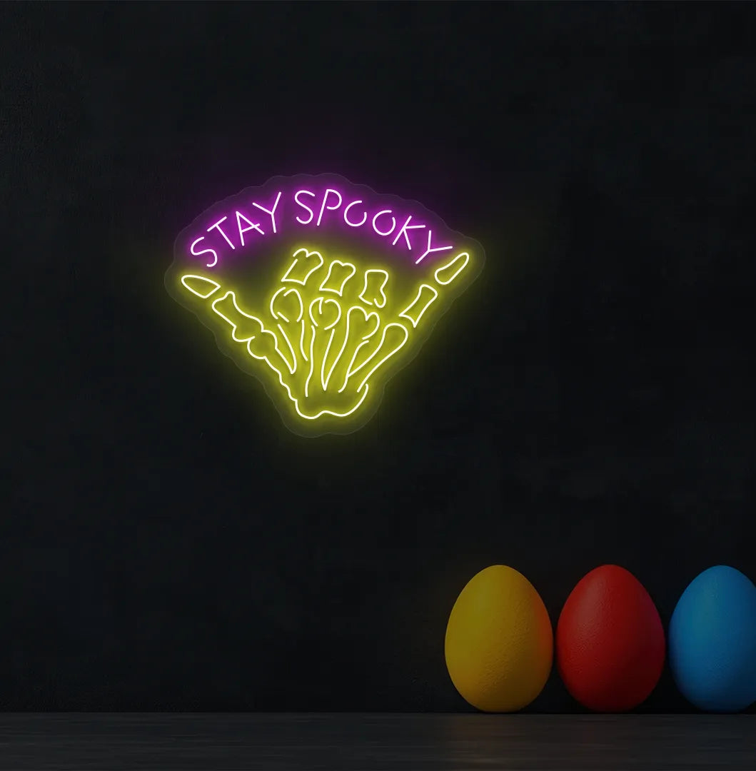 Pink Skeleton Hand Neon Sign glowing on a spooky Halloween themed wall.
