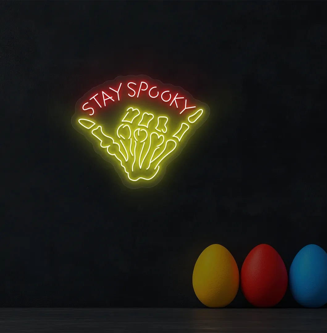 Red Skeleton Hand Neon Sign glowing on a spooky Halloween themed wall.