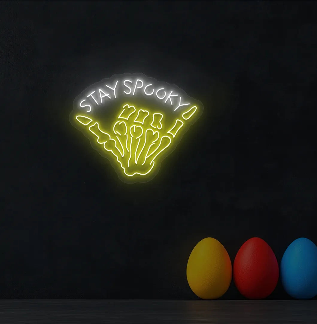 White Skeleton Hand Neon Sign glowing on a spooky Halloween themed wall.