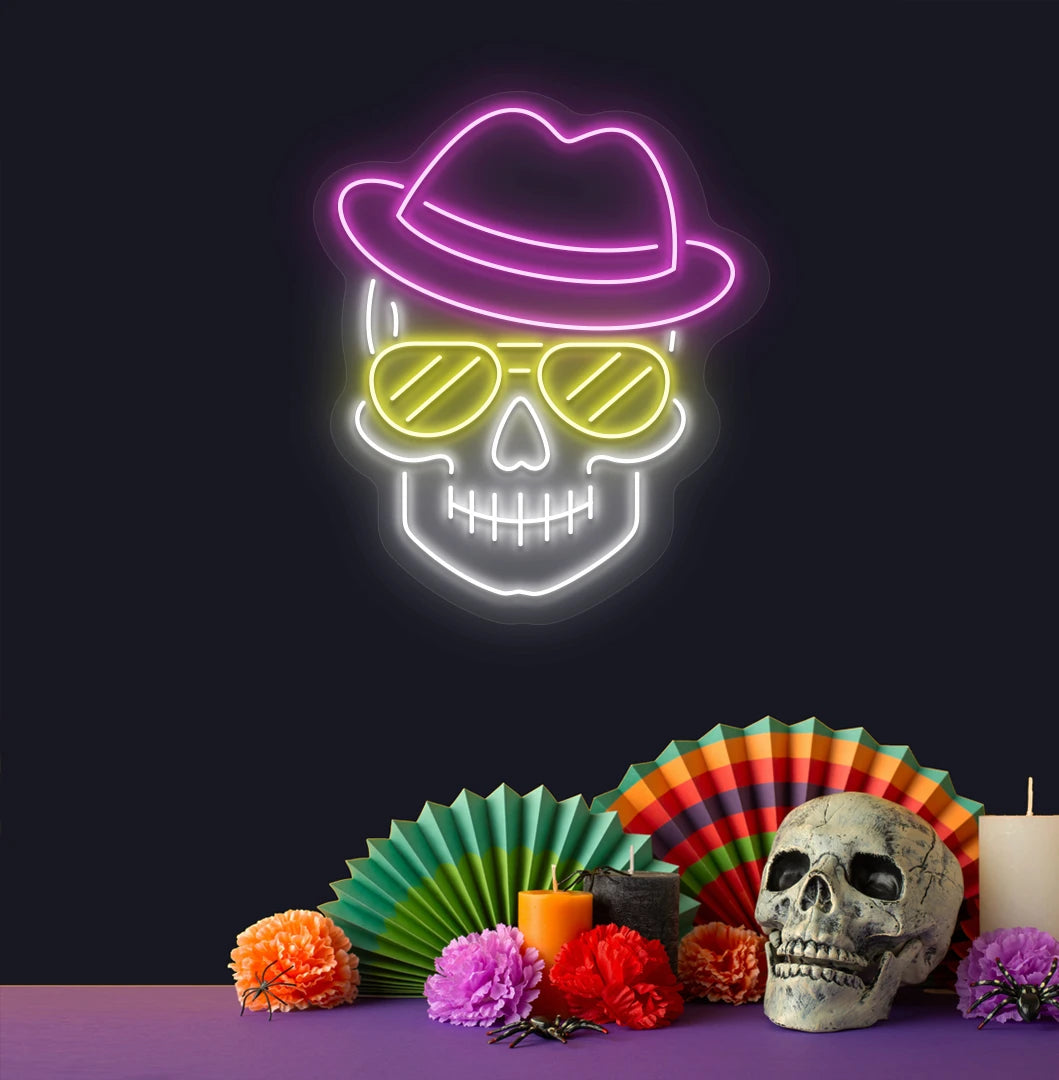 Image of a skull with hat and sunglasses neon sign above human skull glowing on wall in pink color.