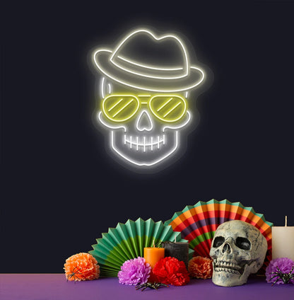 Modern aesthetic wall with skull neon sign glowing warm white above human skull.