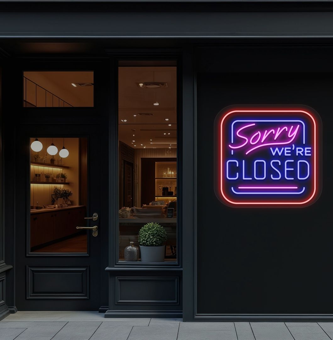 Image of a "Sorry, We're Closed" neon sign glowing on a shop exterior wall in blue color.