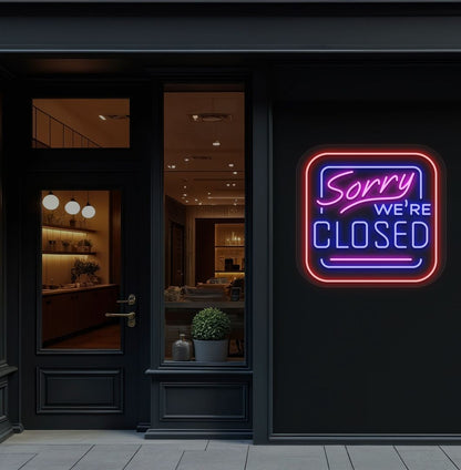 Image of a "Sorry, We're Closed" neon sign glowing on a shop exterior wall in blue color.