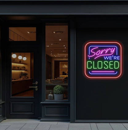 Storefront wall with sorry we're closed neon sign glowing green. 
