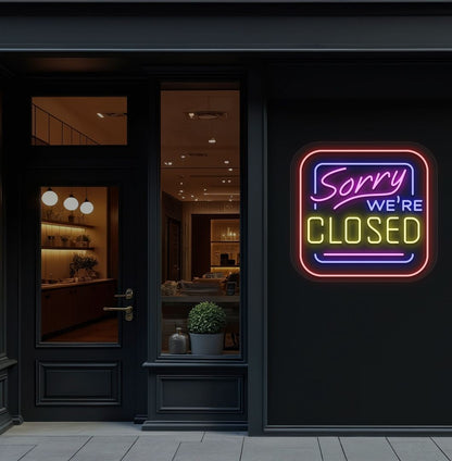 Storefront wall with sorry we're closed neon sign glowing yellow. 
