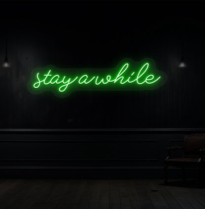 Stylish green LED "stay a while" neon light on wooden wall interior for living room & hallway décor.