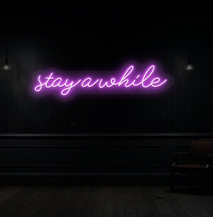 Image of a "stay a while" LED neon sign hanging on a wooden wall in purple color. 
