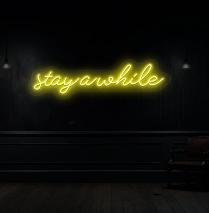 Image of a "stay a while" LED neon sign hanging on a wooden wall in yellow color. 