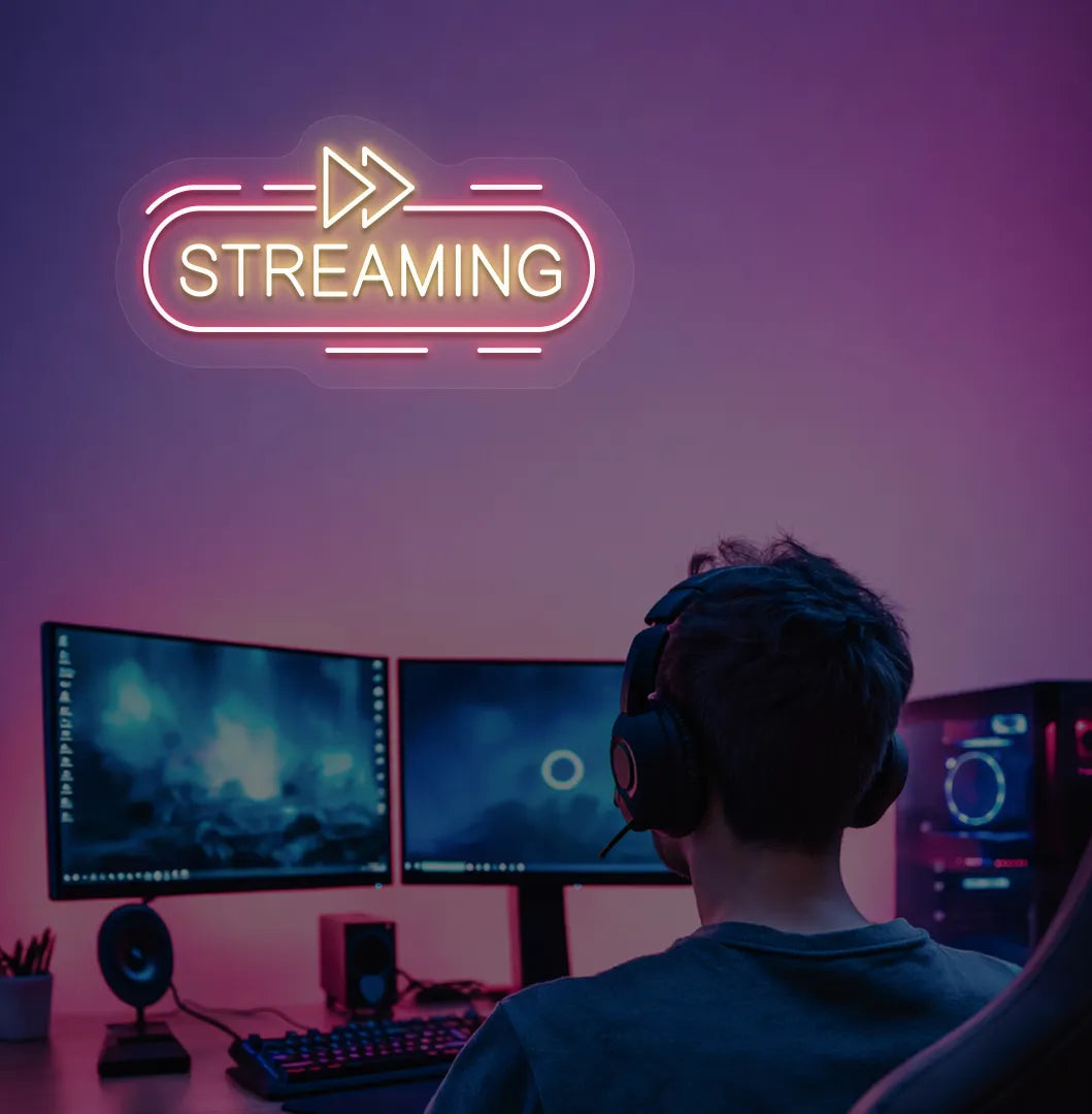 Stylish streaming neon sign in orange mounted on gaming room wall.