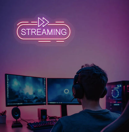 Stylish streaming neon sign in purple mounted on gaming room wall.
