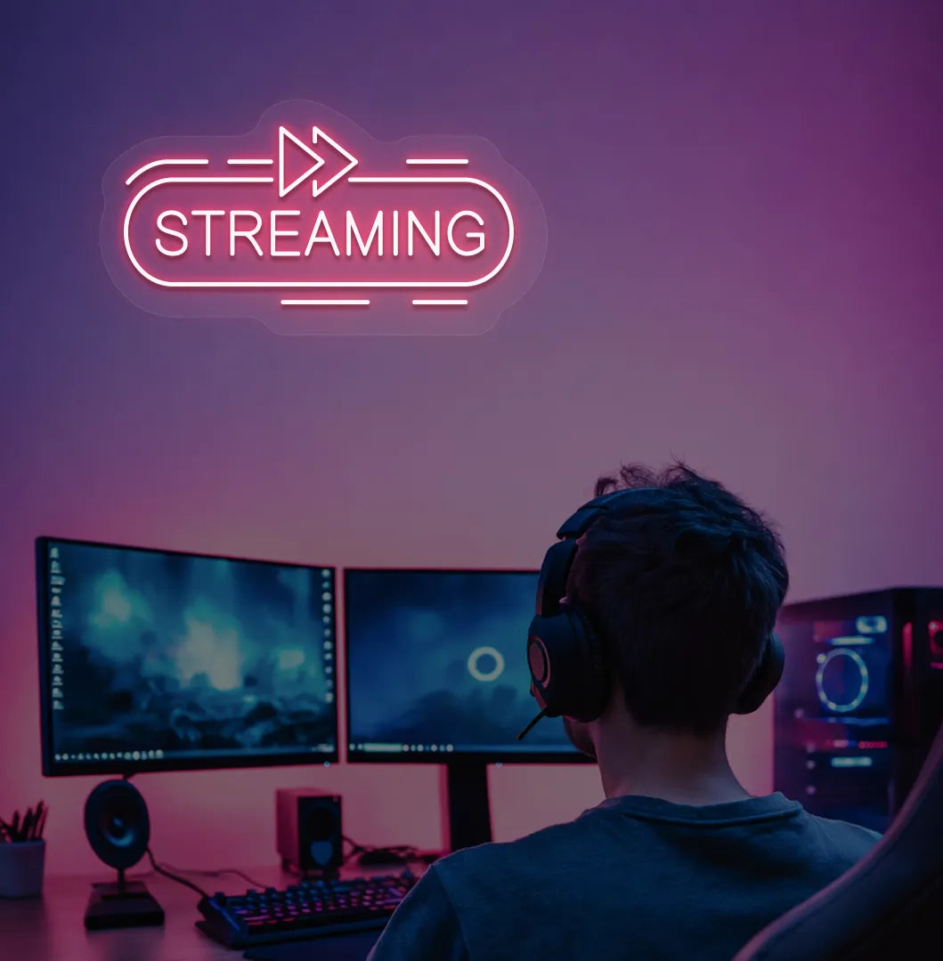 Image of a "streaming" neon sign in red color mounted on gaming room wall.