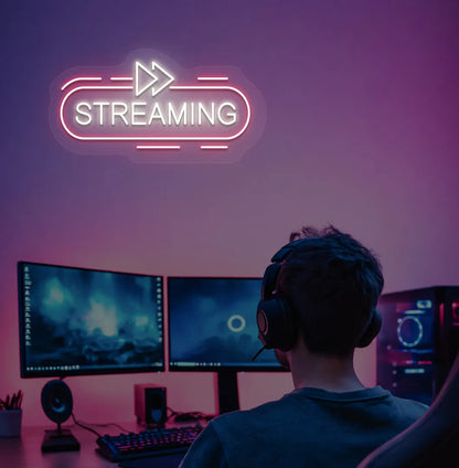 Stylish streaming neon sign in warm white mounted on gaming room wall.