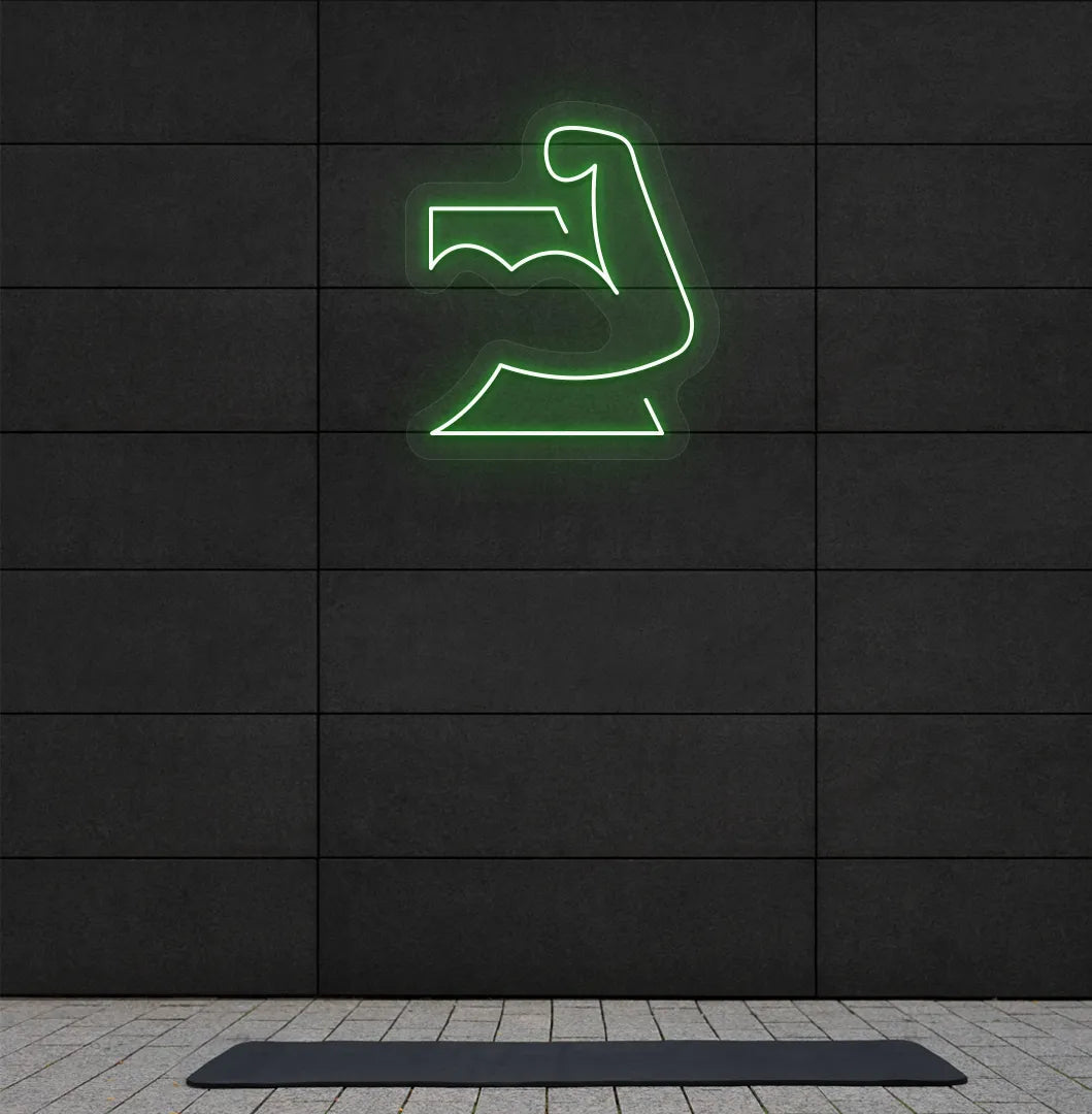 Trendy strong body neon sign in green mounted on fitness wall.