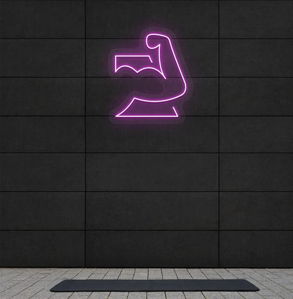 Image of a stylish strong body neon sign in pink mounted on gym wall.