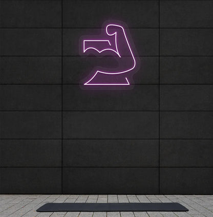 Trendy strong body neon sign in purple mounted on fitness wall.