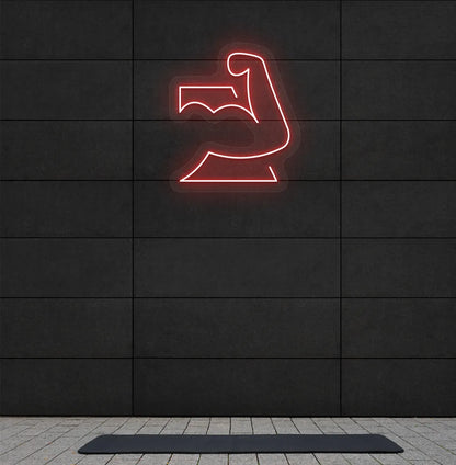 Image of a stylish strong body neon sign in red mounted on gym wall.