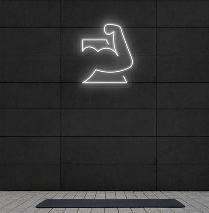 Image of a stylish strong body neon sign in white mounted on gym wall.