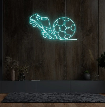Image of a "Football with shoe" neon sign glowing ice blue on sports-themed wall.