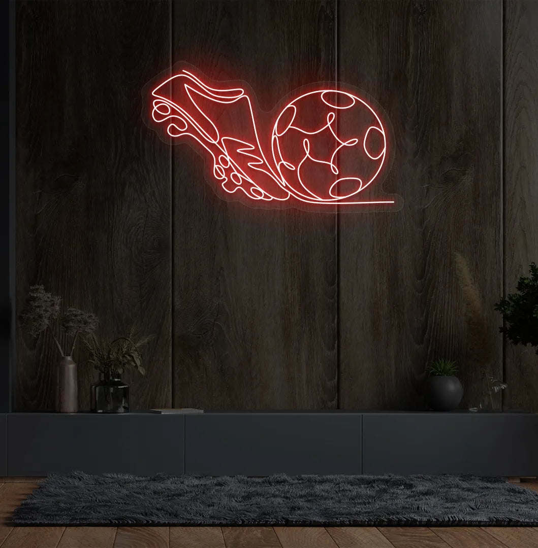 Image of a "Football with shoe" neon sign glowing red on sports-themed wall.