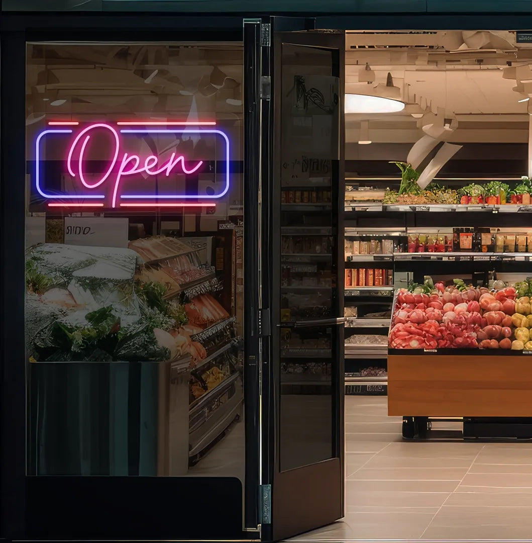 Image of an open LED neon sign glowing on a supermarket glass door in pink color.