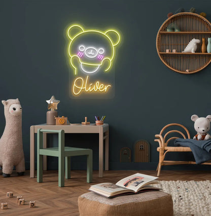 Teddy Bear Nursery Name neon sign glowing orange on decorative wall.