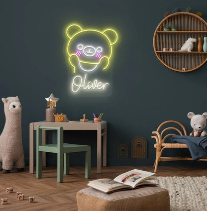 Teddy Bear Nursery Name neon sign glowing warm white on decorative wall.
