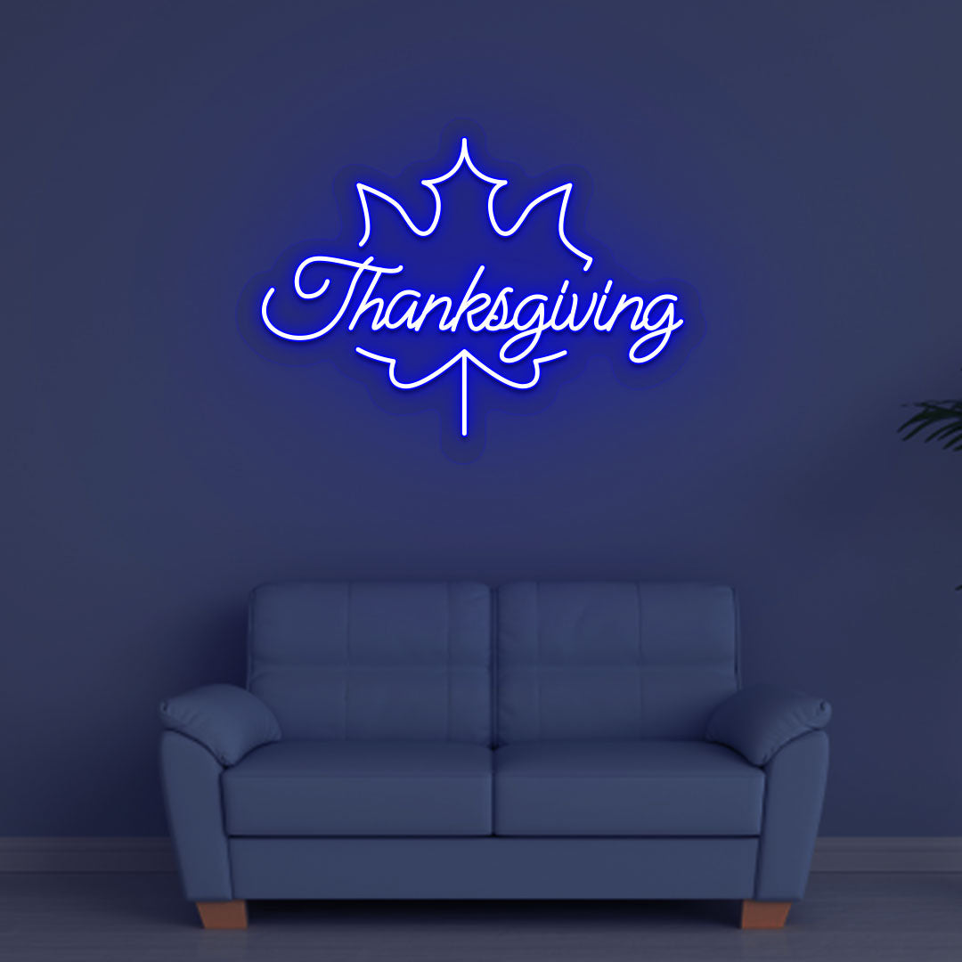 A bright blue Thanksgiving neon sign for the holiday hanging on a wall. Perfect for home décor, kitchen walls, and holiday parties.