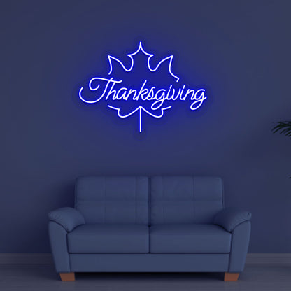 A bright blue Thanksgiving neon sign for the holiday hanging on a wall. Perfect for home décor, kitchen walls, and holiday parties.