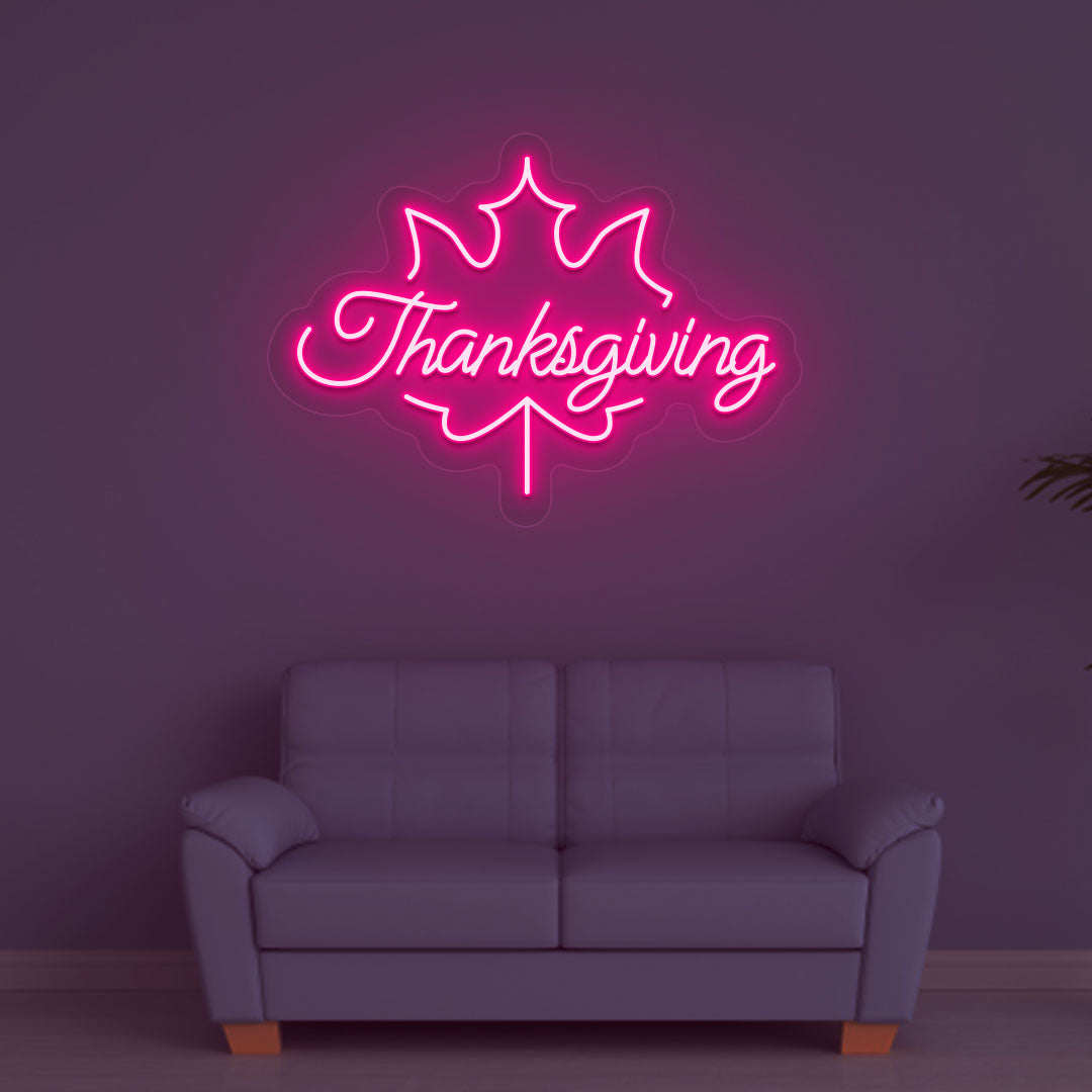 An image of a Thanksgiving neon sign in pink is displayed on a wall, suitable for home decor and various environments.