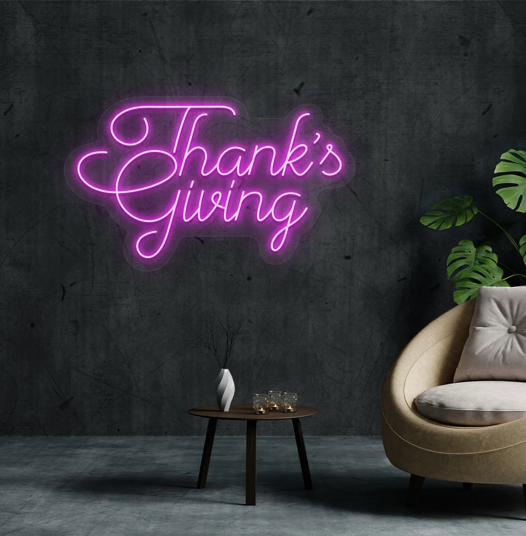 Image of a Thanksgiving neon sign mounted on an aesthetic living room wall in pink color.
