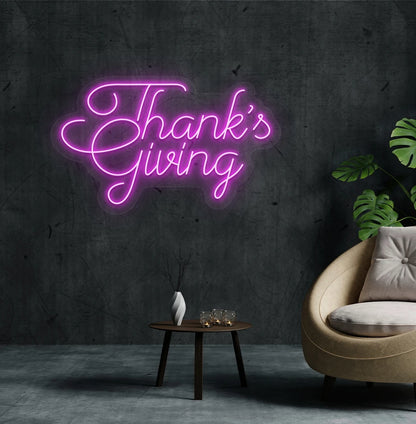 Image of a Thanksgiving neon sign mounted on an aesthetic living room wall in pink color.
