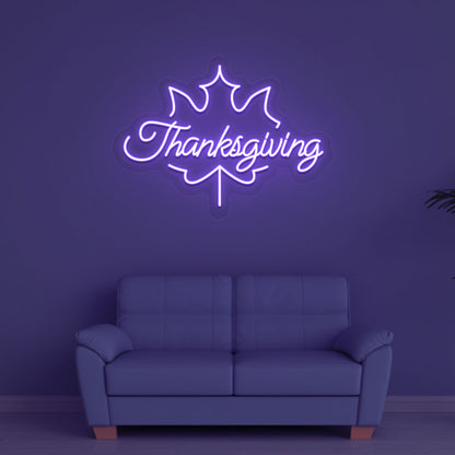 Festive season with a Thanksgiving purple neon sign glowing on a wall.