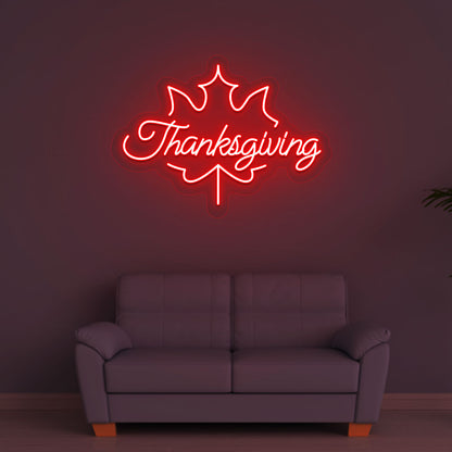 Festive season with a Thanksgiving red neon sign glowing on a wall.