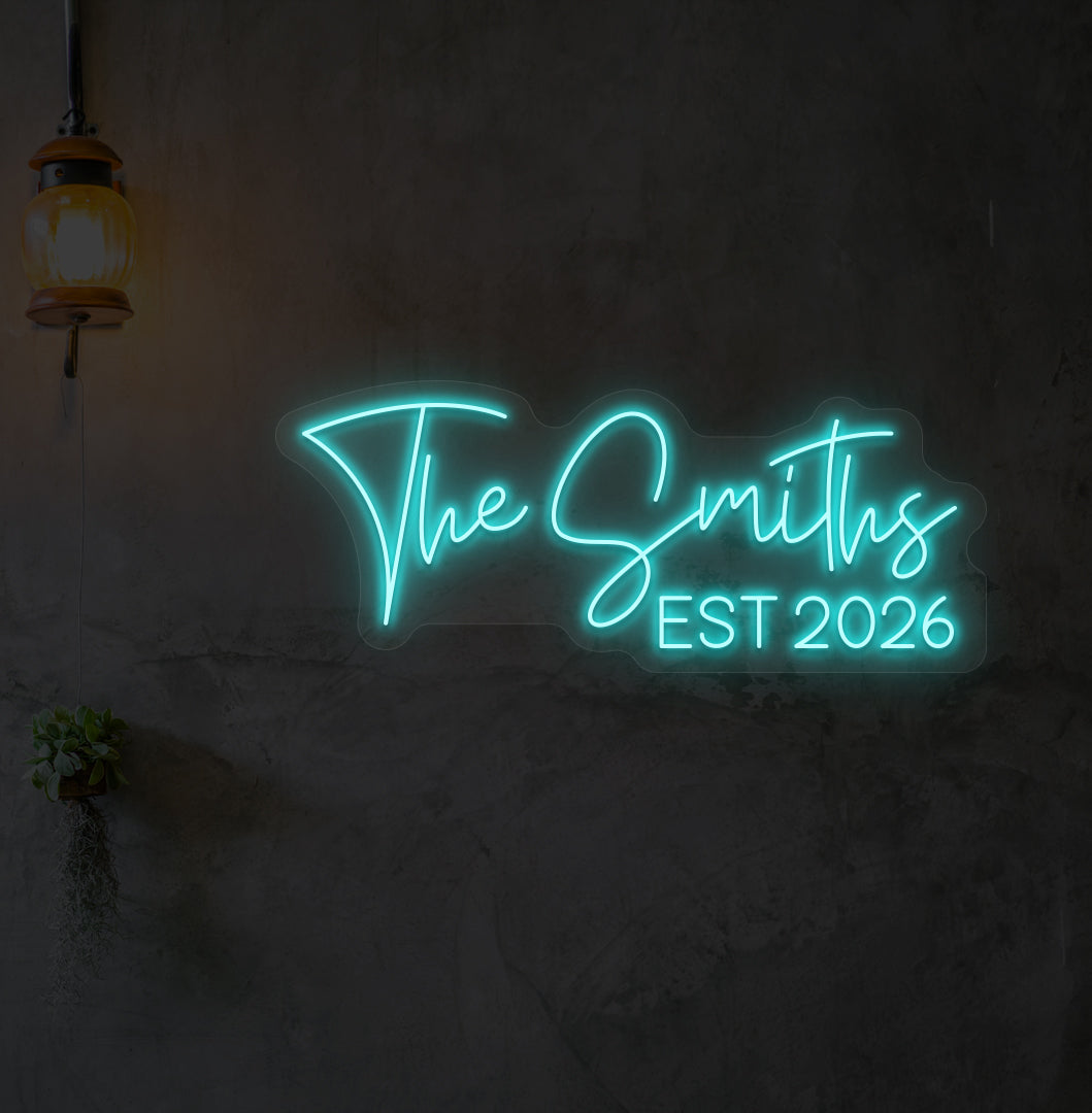 Image of "the Smiths" LED neon sign glowing on wall in ice blue.