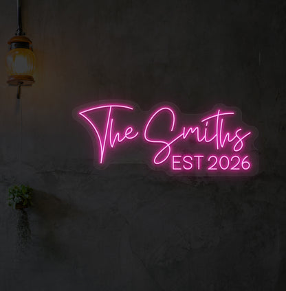 Image of "the Smiths" LED neon sign glowing on wall in pink.